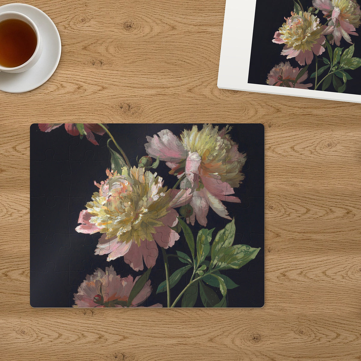 Memory Lane puzzle: Peonies in Bloom. The finished 30-piece 14″ × 11″ puzzle on a table beside its white gift box (product illustration)