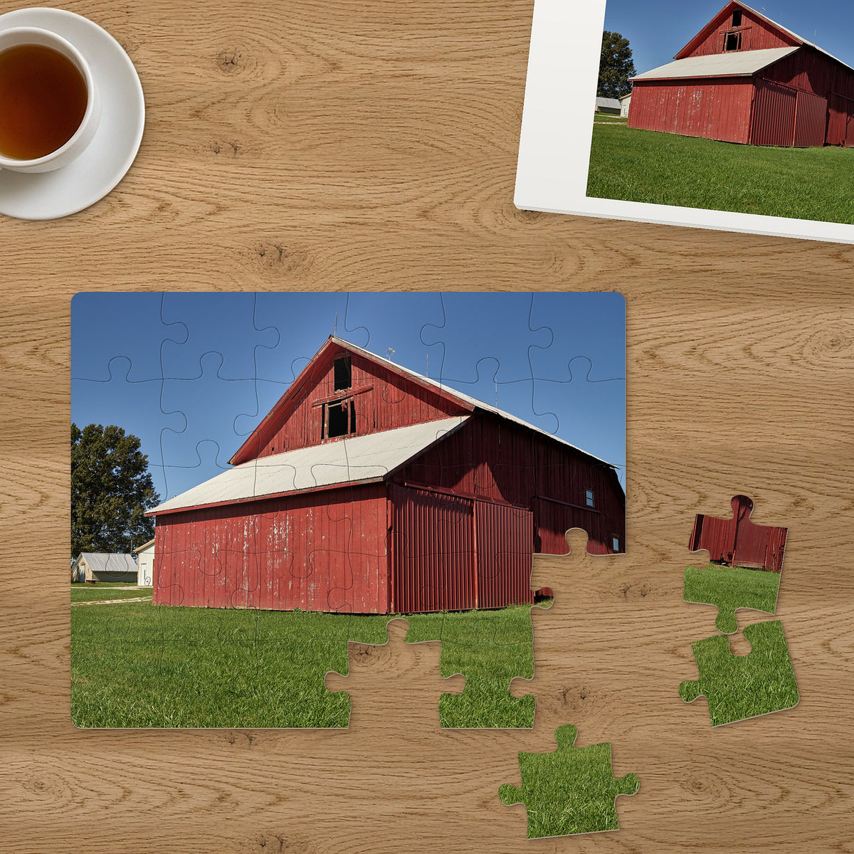 Memory Lane puzzle: Red Barn Morning. Three of the 30 extra-large pieces, each about 2¼″ across, lifted out beside the puzzle (product illustration)