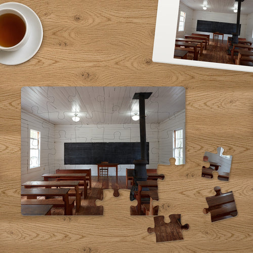 Memory Lane puzzle: One-Room Schoolhouse. Three of the 30 extra-large pieces, each about 2¼″ across, lifted out beside the puzzle (product illustration)